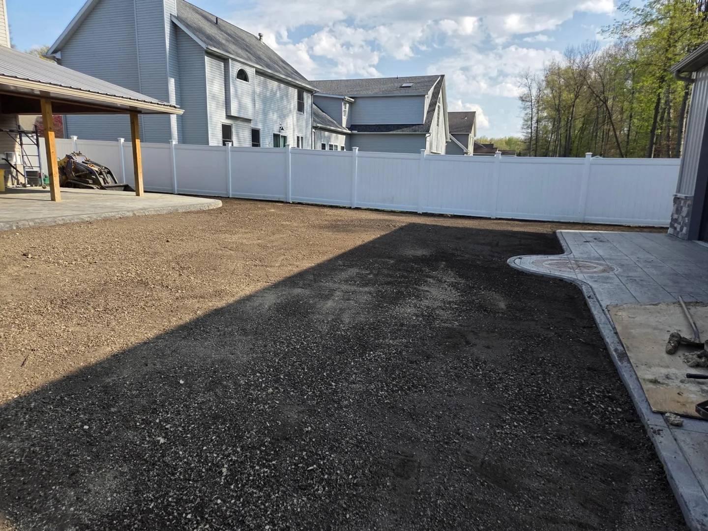 Prepared soil alongside the patio and fence