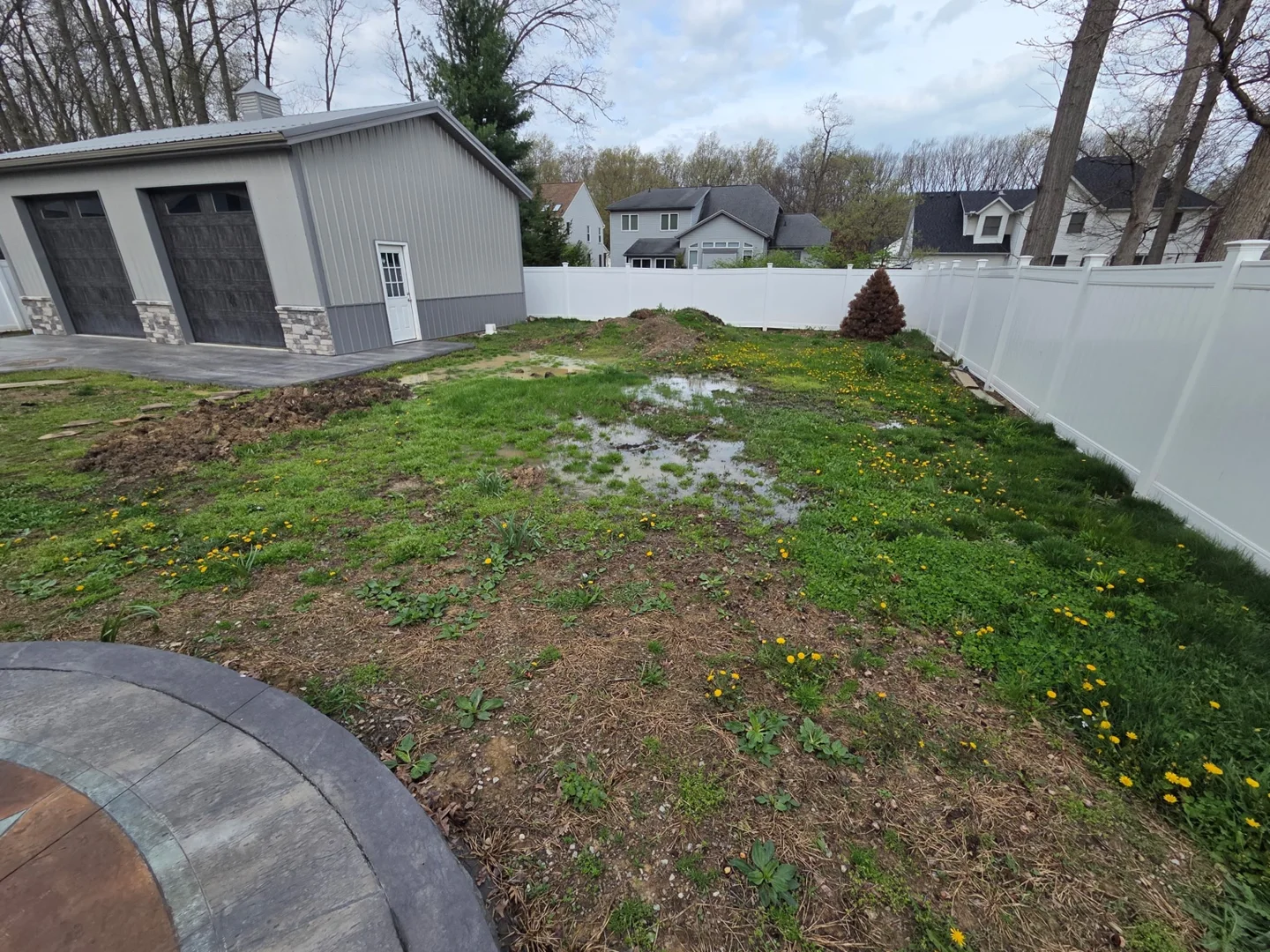 Standing water and thin grass in a backyard before YardBros renovation work